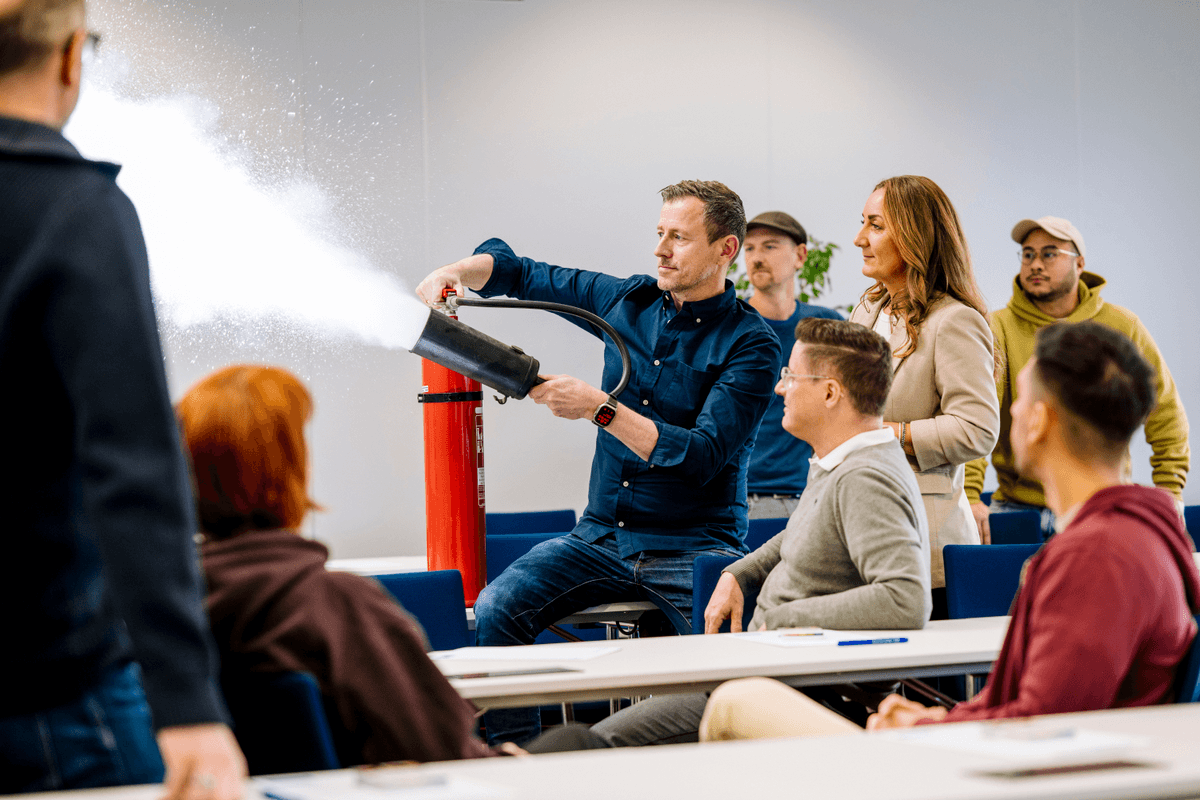 Dozent demonstriert den Einsatz eines Feuerlöschers im VdS-Seminarraum.